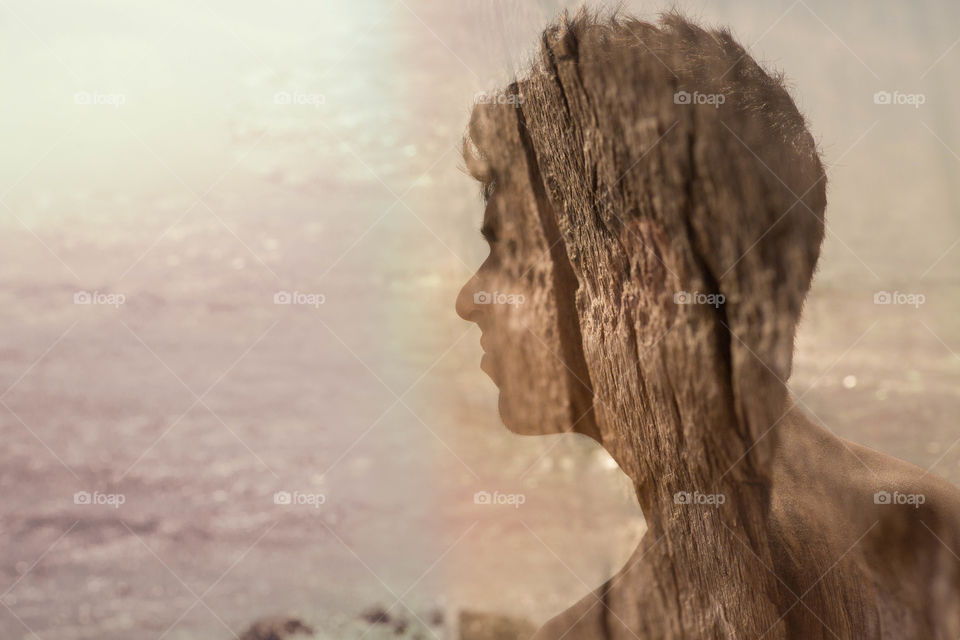 Multi exposure view of a person against tree trunk