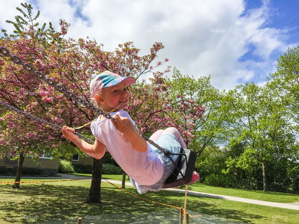 Girl enjoying on swing in park