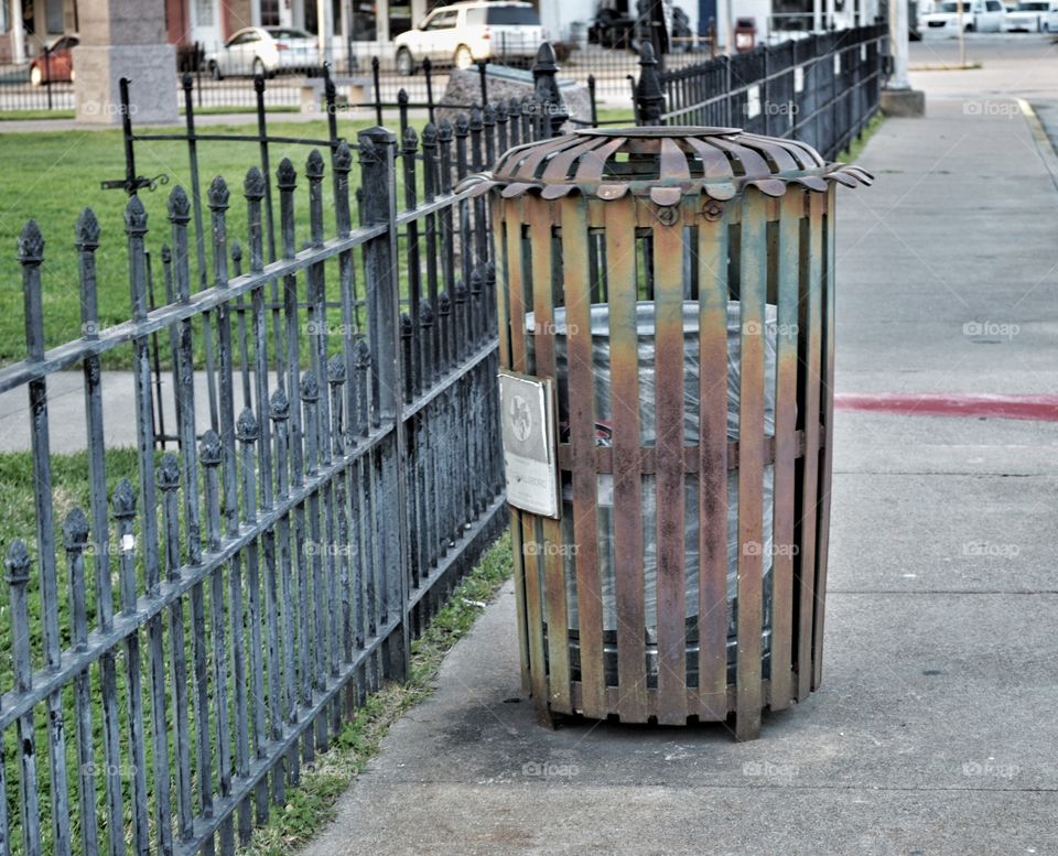 Ornate iron trash can cover to compliment historic down town neighborhood. 