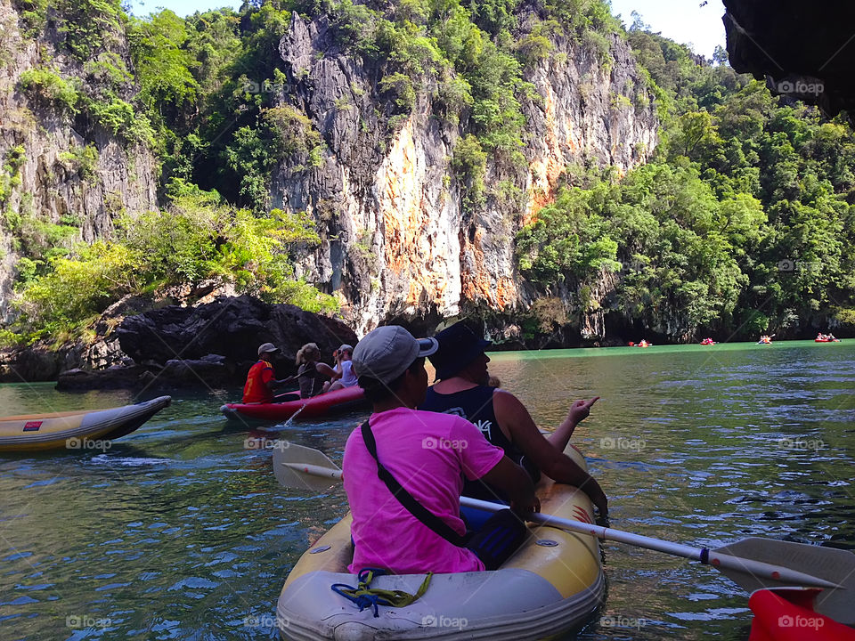 Summer family fun activity - swimming in boat in lake among the rocks 