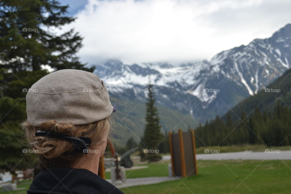 Back view of woman looking at beautiful scenery mountains in the Canadian Rockies 