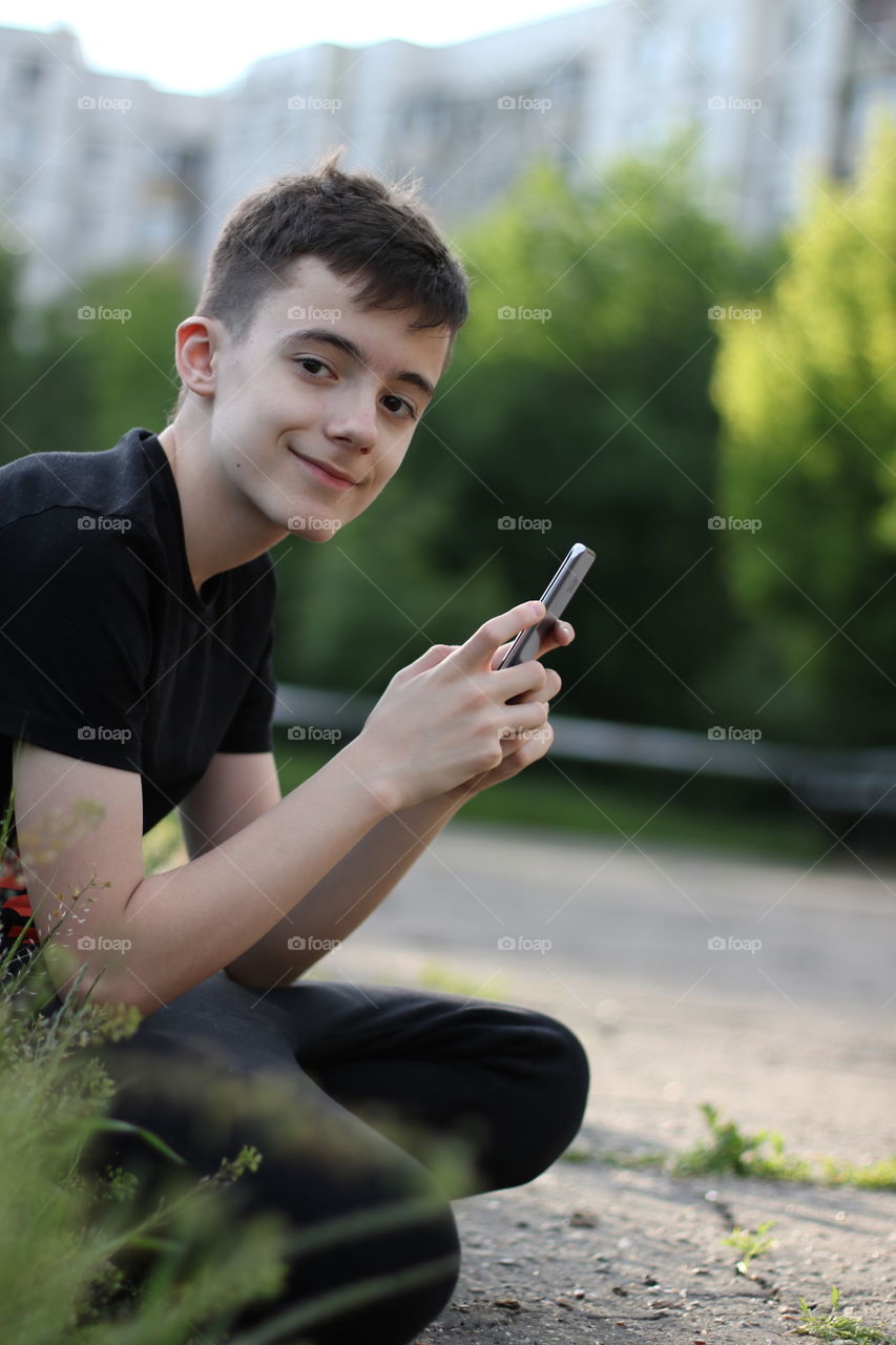 Portrait of teenage boy use the mobile phone.