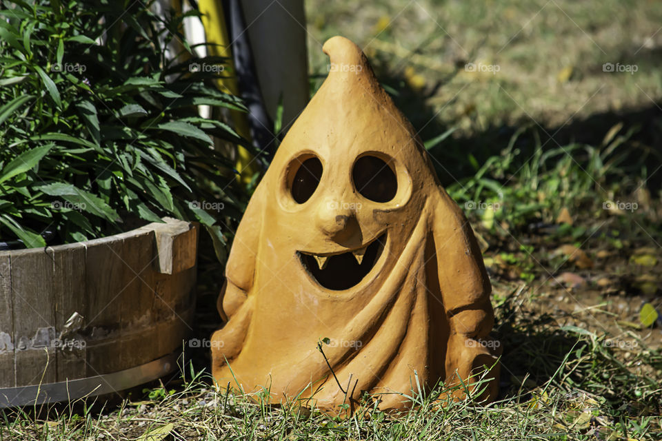 Halloween Brown clay doll shape ghost in garden.