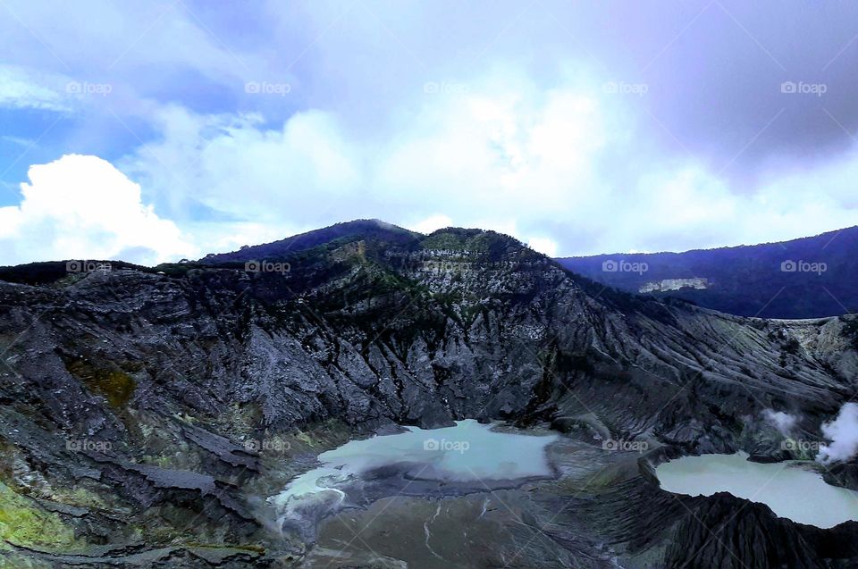 Volcano from the side of the crater, view of an active volcano, Mount Tangkuban Perahu Indonesia, visible clouds refract white, sky looks bright blue, atmosphere during the day, cool temperaur