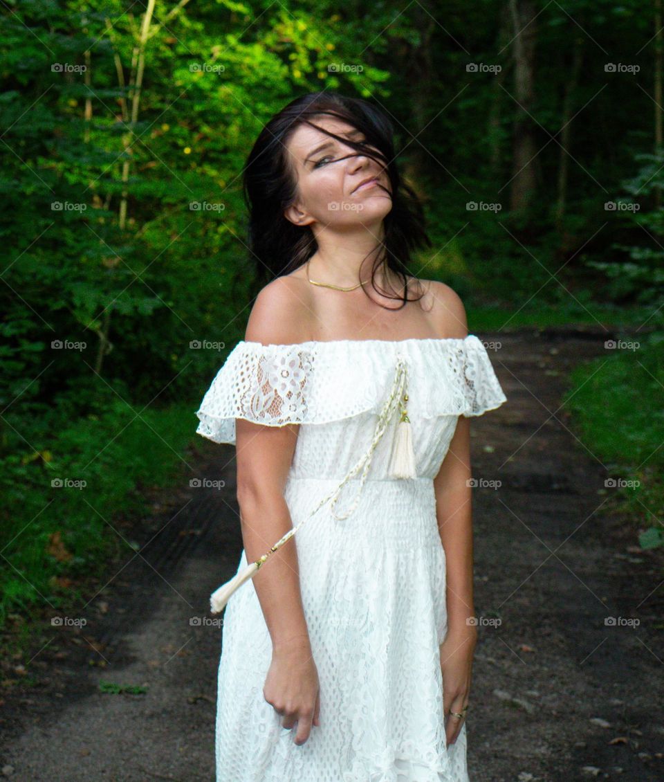 Beautiful woman plays with her hair. 
Blowing in the wind.White dress and  mystetious smile <3 ❤️🧡💛💚💙