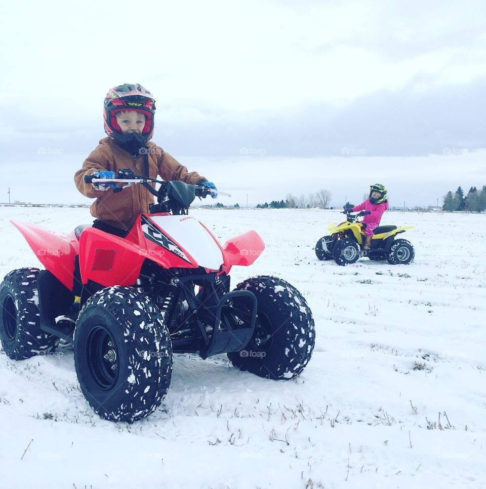 Children riding snowmobile in winter