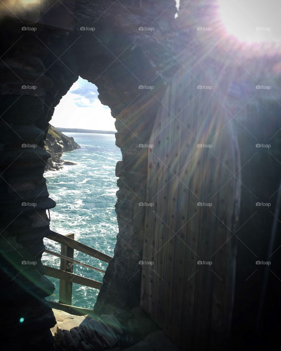 Lens Flare on King Arthur's castle. Playing peek-a-boo with the sea. 