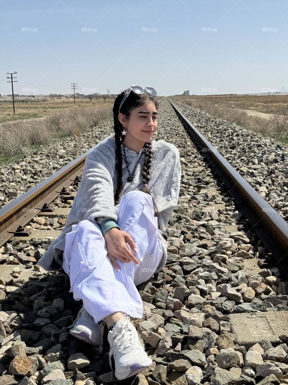 A girl sitting on the train tracks