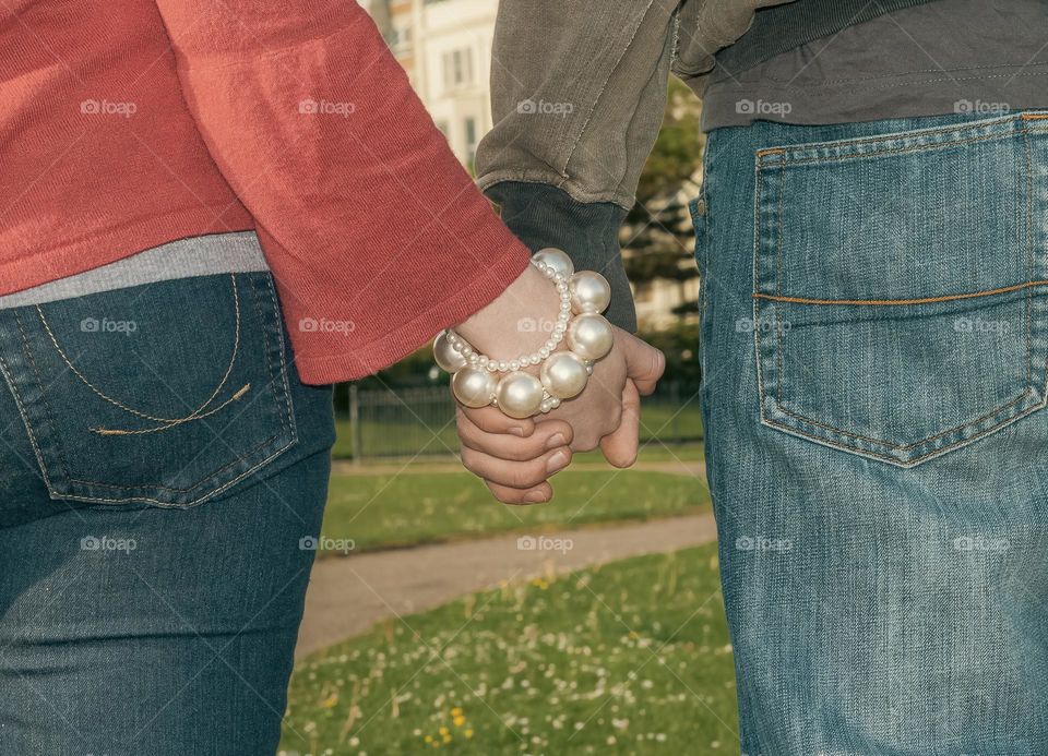 Young couple holding hands on a first date in the park