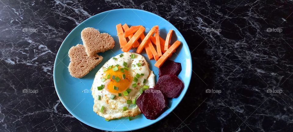 omelette, bread, carrots, onion and beet on the plate