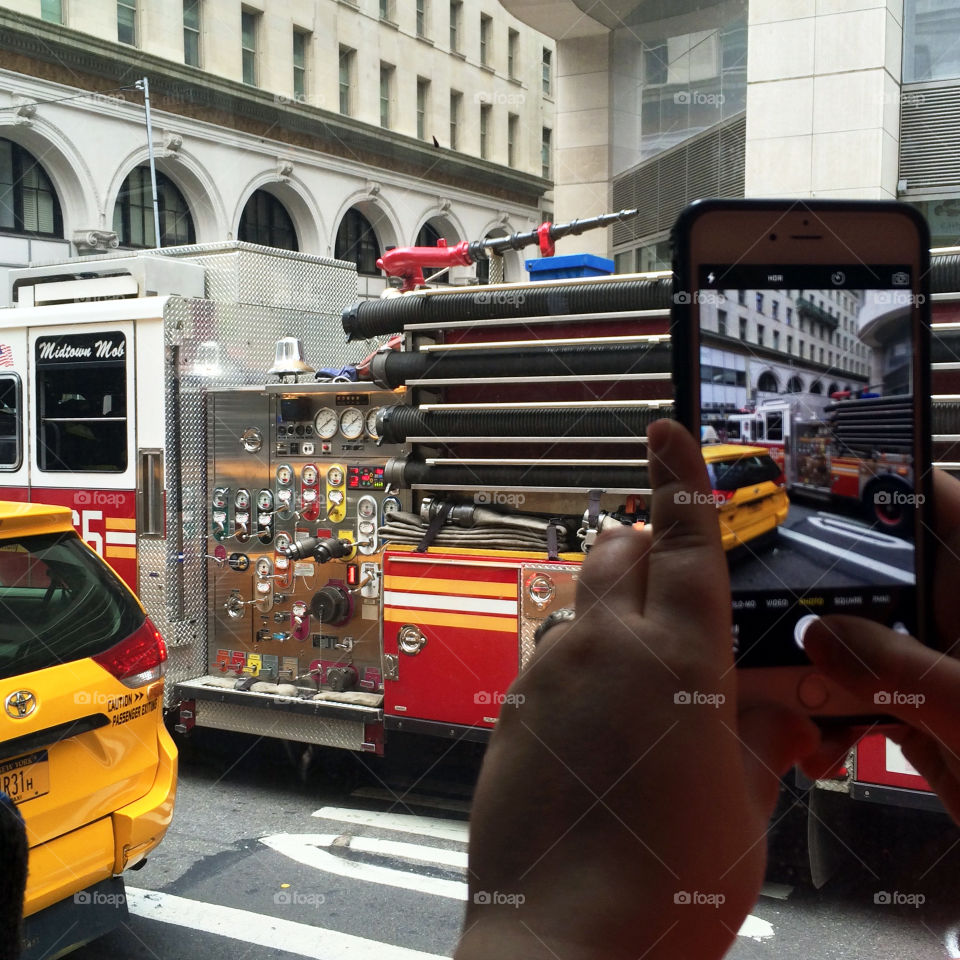 New York City.  Fire truck going by as we sat in the tour bus, can be seen also in the cell phone taking pictures 