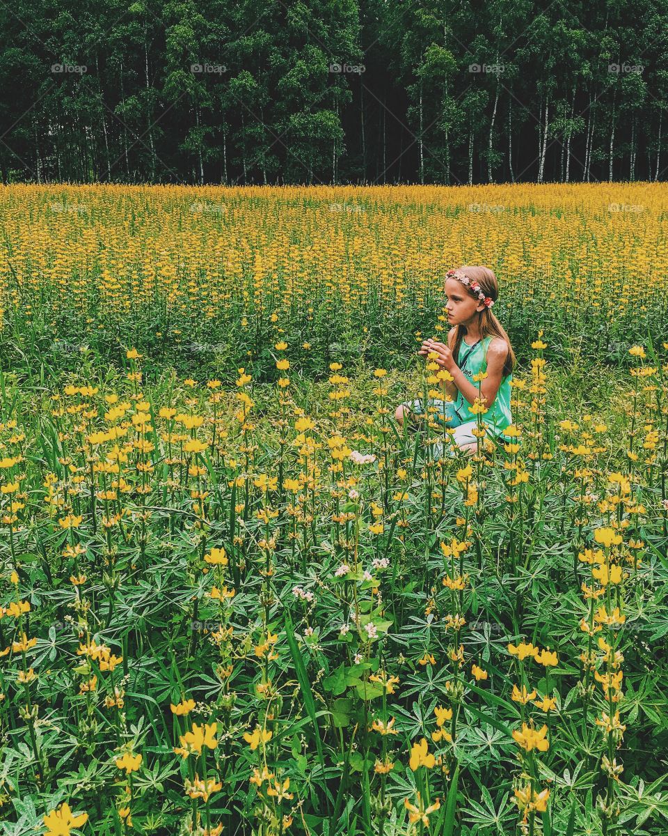 Girl smelling flowers in field