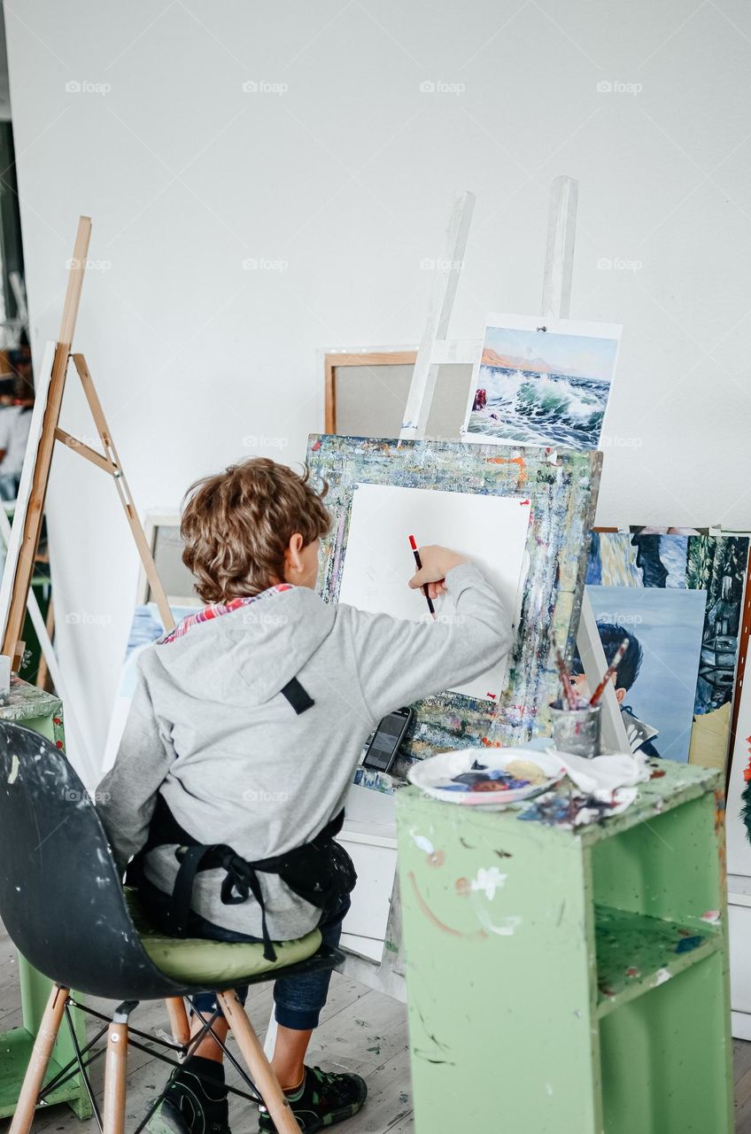 The boy draws in the art studio.