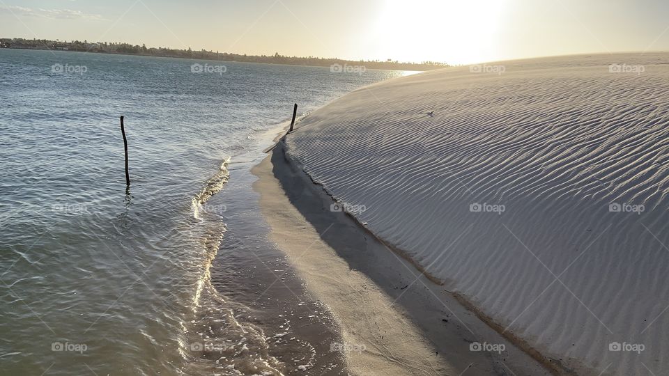 White dunes and sea at sunset light 