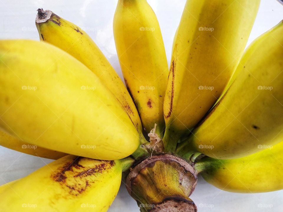 Yellow ripe bananas on white floor