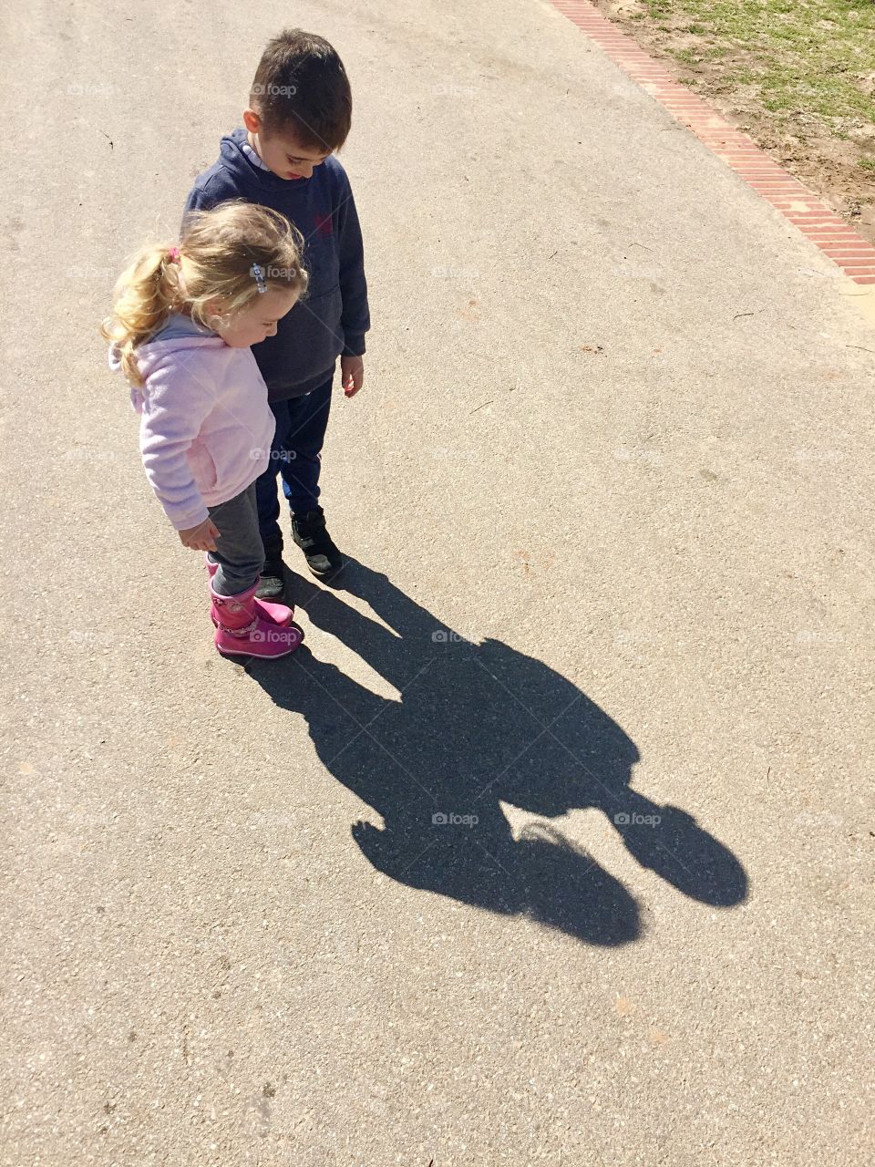 High angle view of girl and boy standing on road
