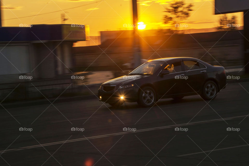 Car in motion on a sunset background.