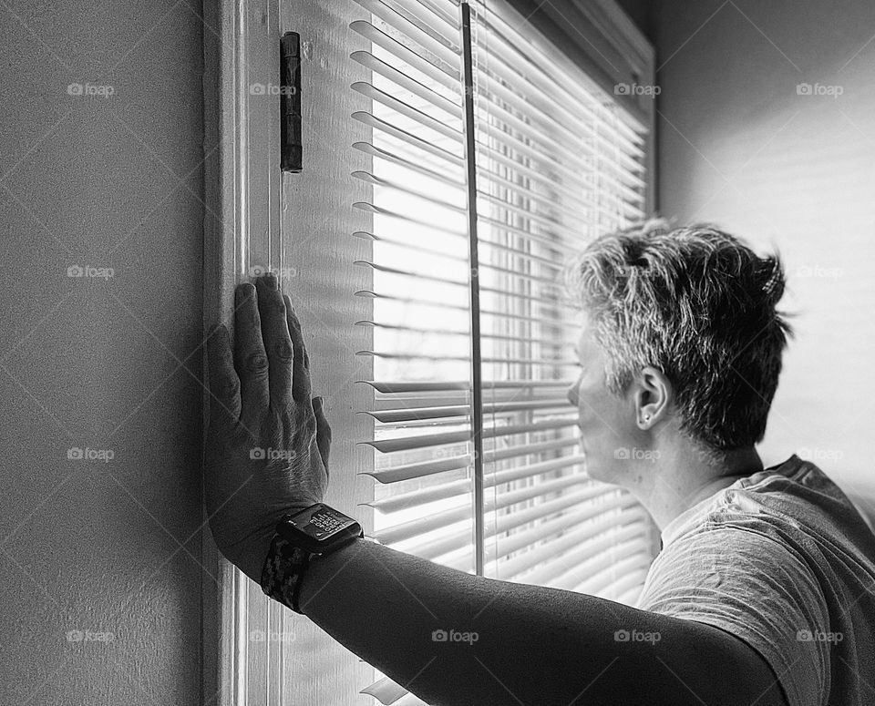 Woman looking out window, woman watches neighborhood, woman enjoying the view, black and white portrait of woman and window 