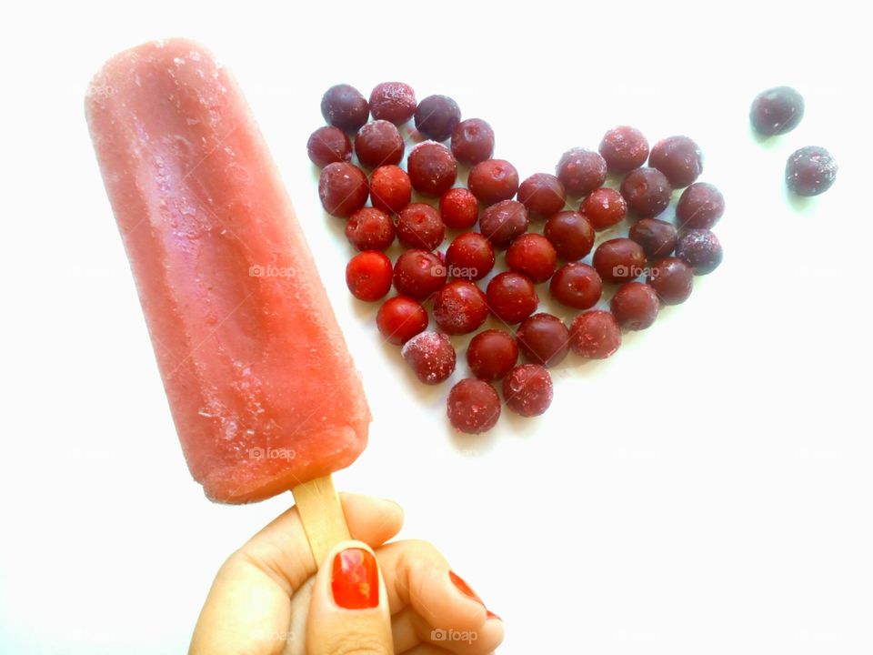 ice cream in hand and cherry red heart on a white background