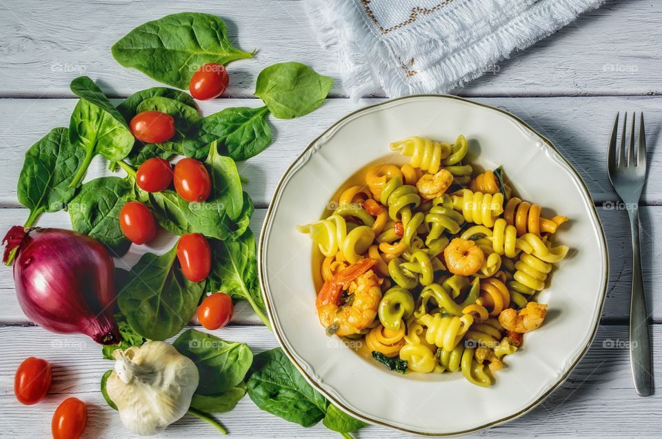 Cooking pasta with vegetables and prawns