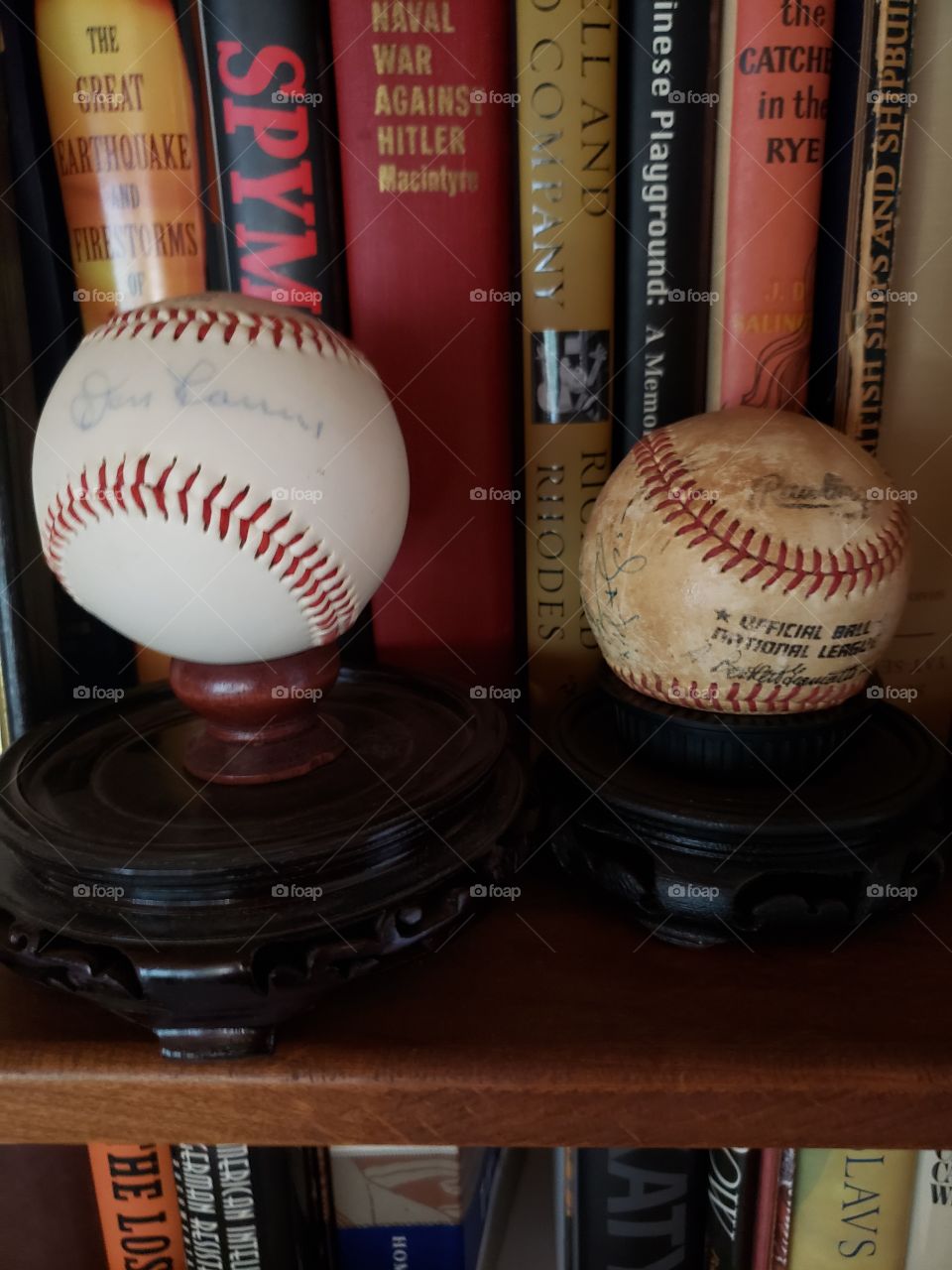signed baseballs on bookshelf
