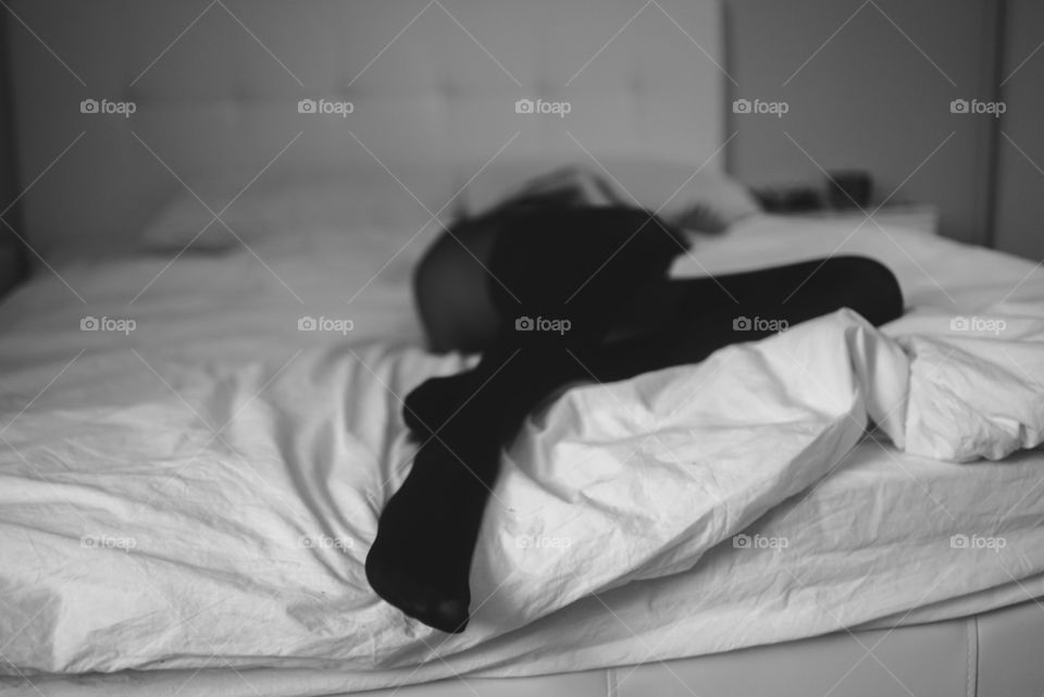 woman in stockings laying on a bed