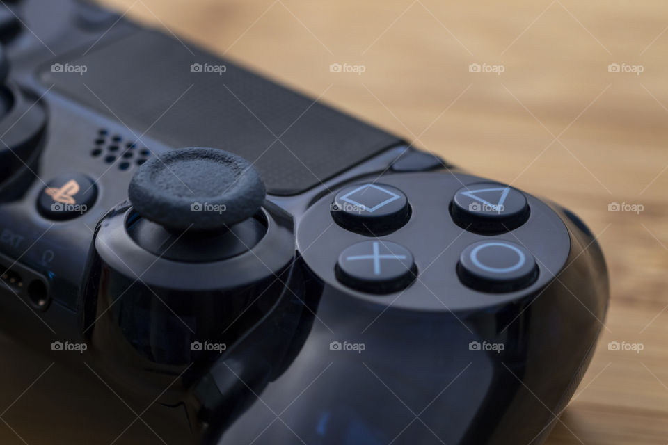 A PlayStation 4 controller has a lot of round and eliptical shapes, inclusief the joysticks and buttons a player play with.