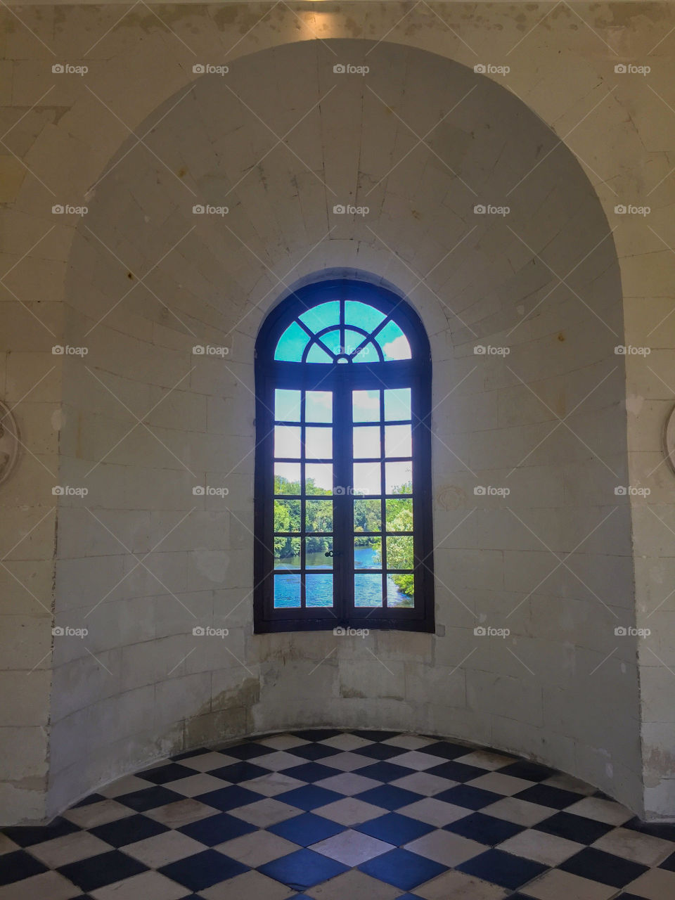 Big window in the old castle with the view to the river and forest