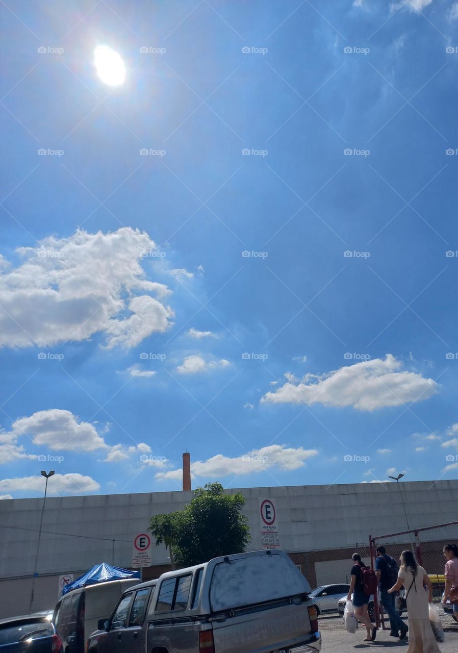 Tarde de Céu azul, Sol forte,  nuvens flutuantes e carregadasl