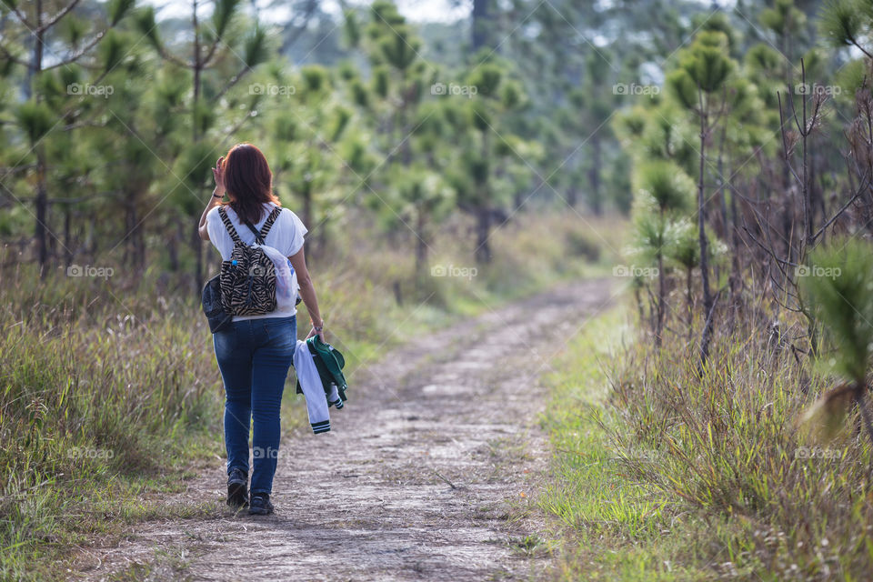 Girl walking alone in the forest path