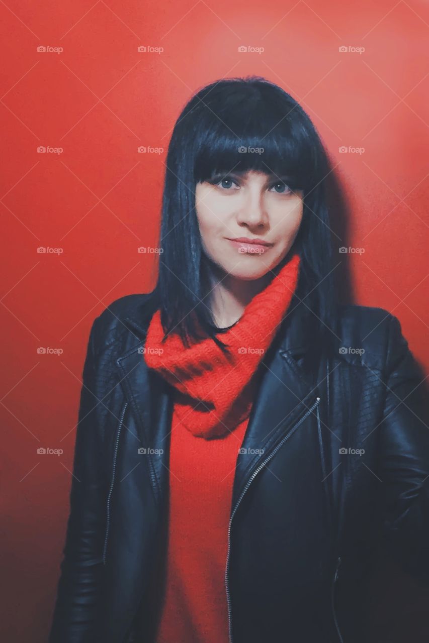 Portrait of the girl standing by red wall