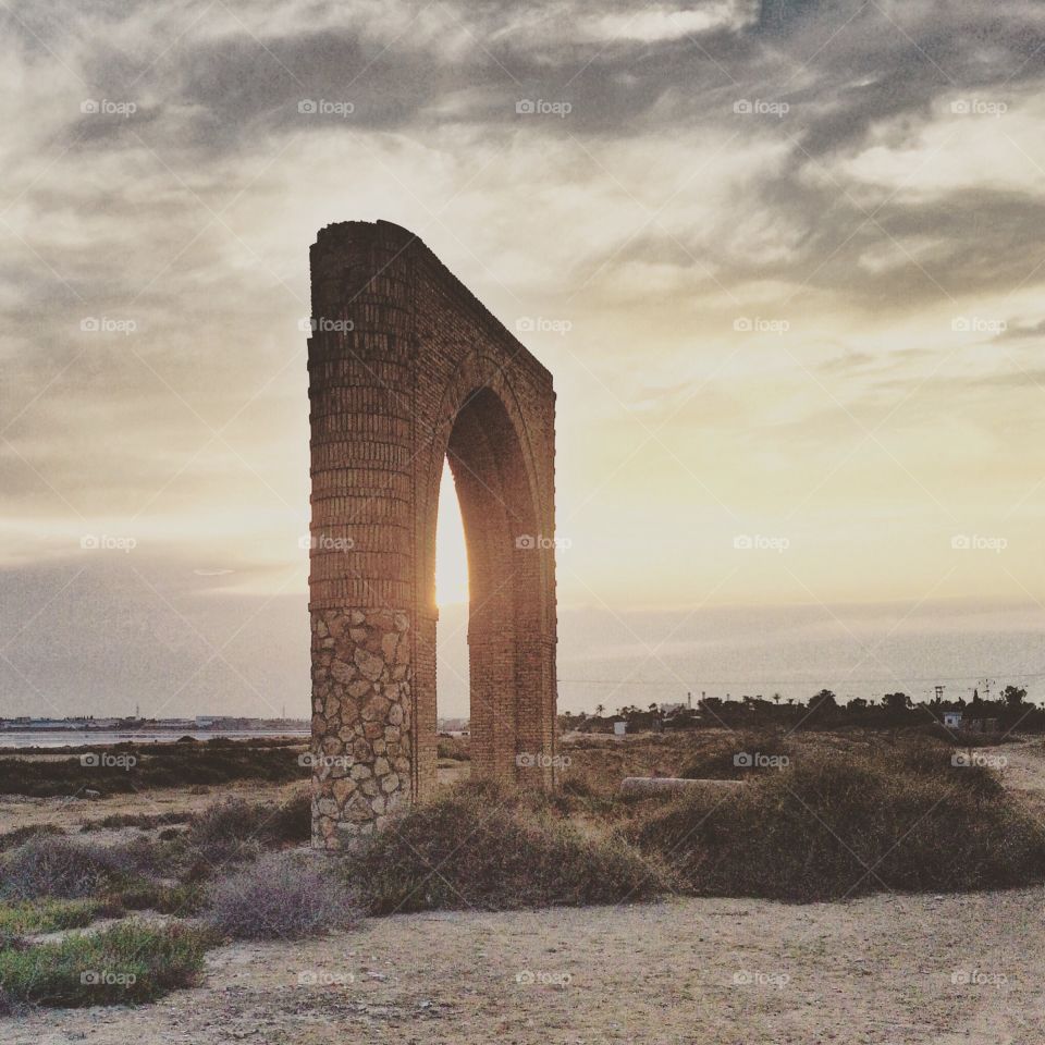 sun seen from archeological door at sunset 