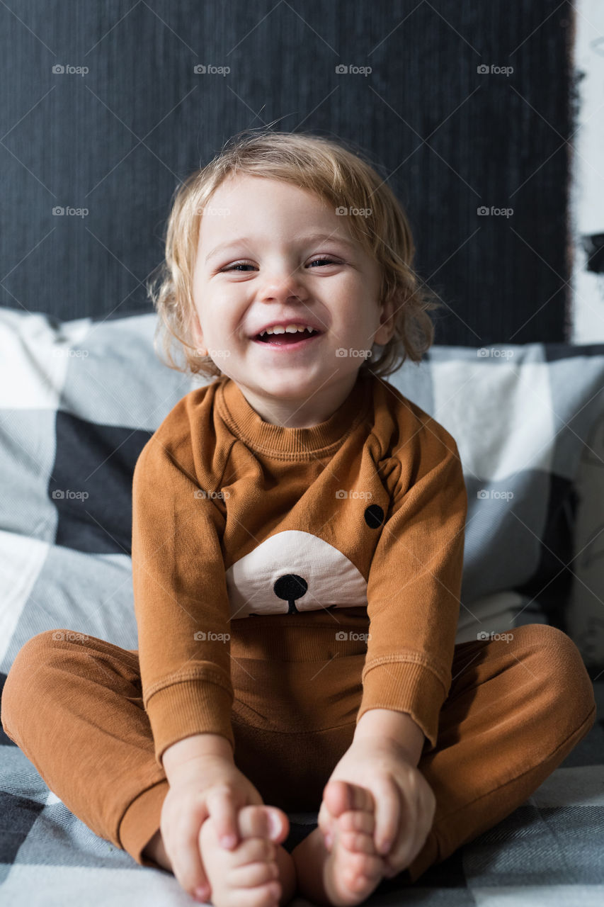 beautiful curly-haired boy smiles and rejoices