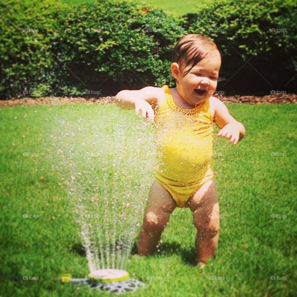 Baby, it's hot outside!. My niece had been walking for a month. We set up a sprinkler and were surprised to see her waddle over. She loved it!