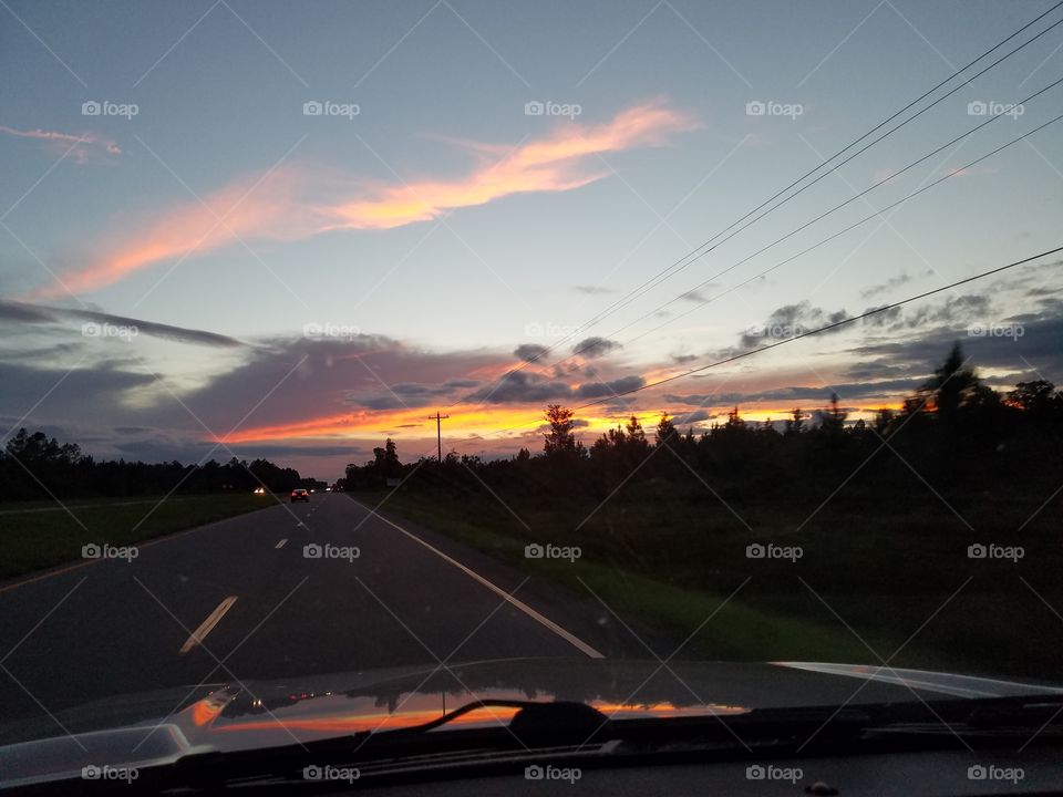 Car driving on road during sunset