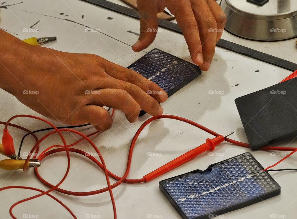 Building An Electric Circuit. Hands Assembling An Electrical Circuit
