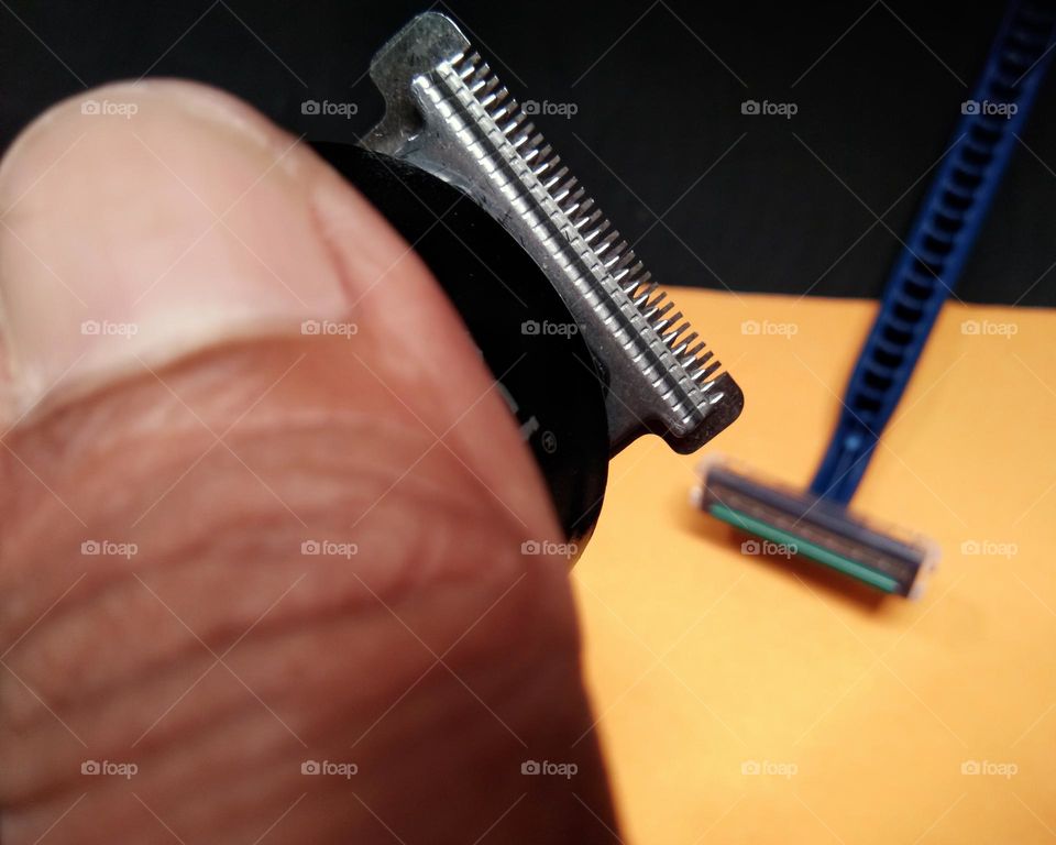 to shave the beard.  trimmer closeup,  against the razor