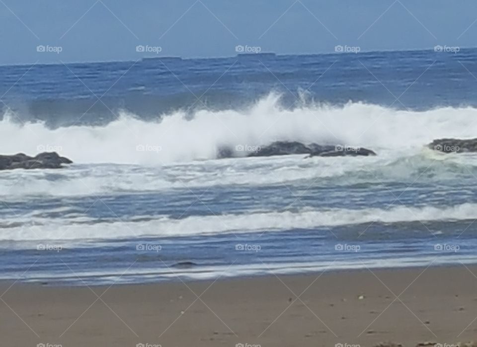 Barges on ocean being crashing waves