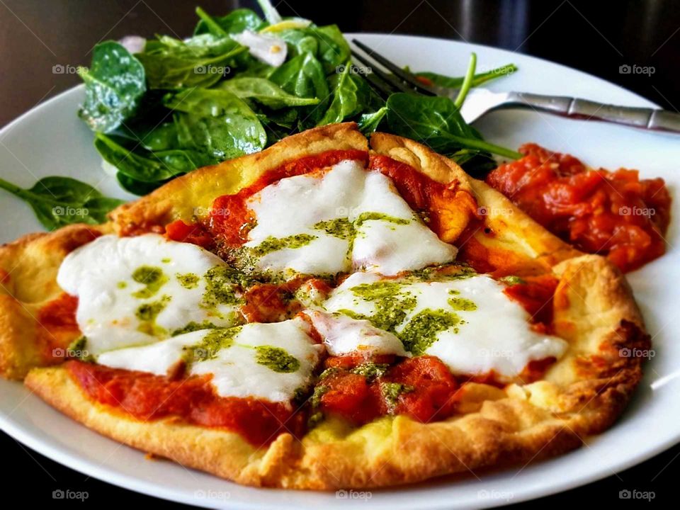 Salad and pizza in plate