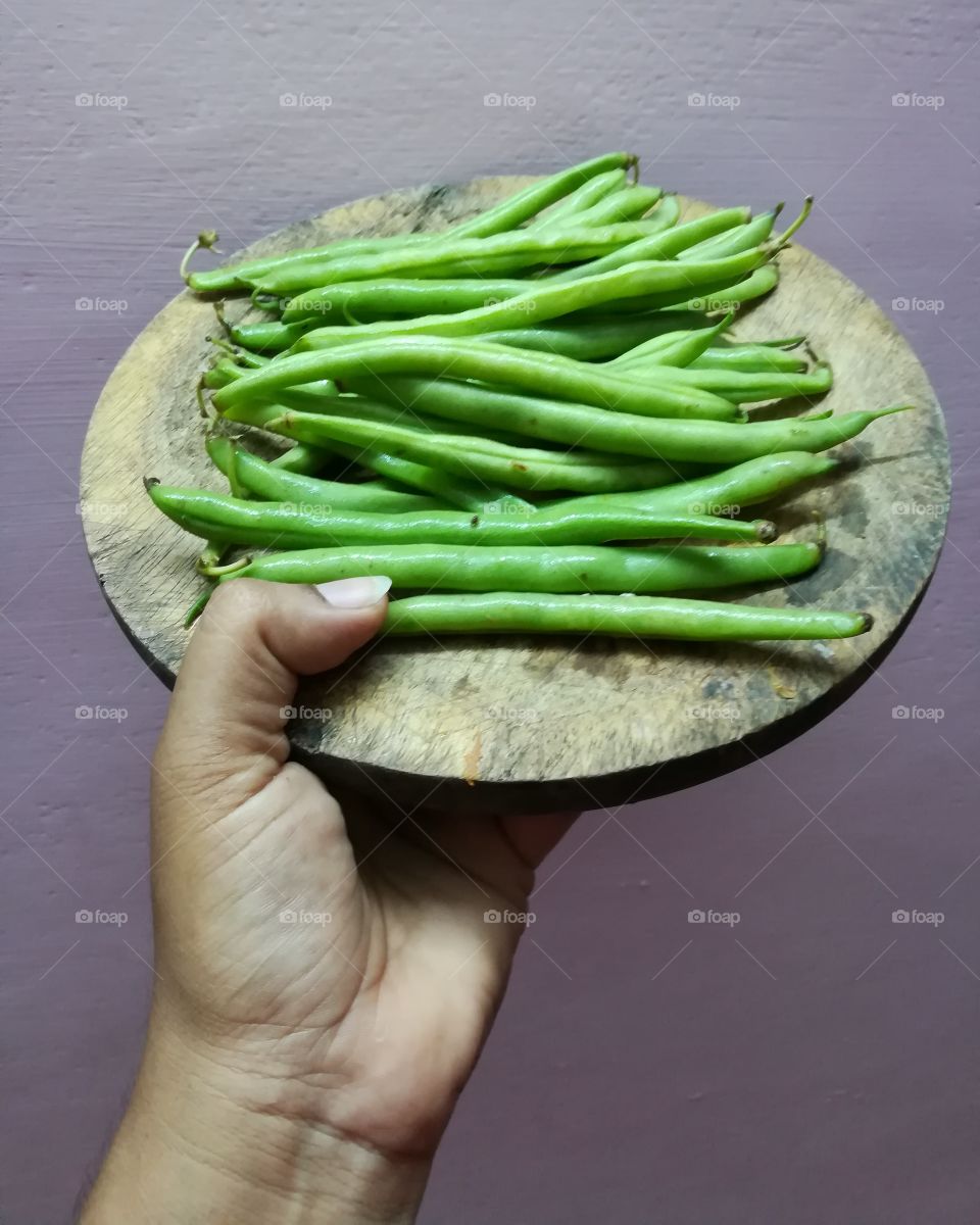 Close-up of a hand holding green beans