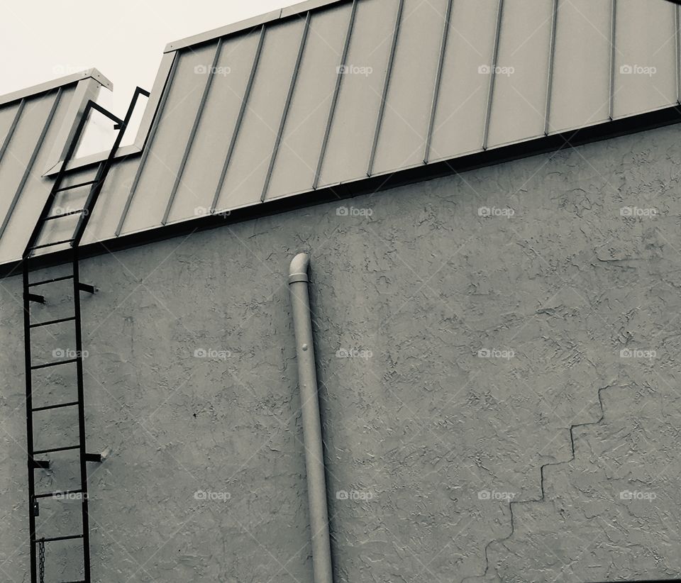 A wall with a ladder and drawn on stairs in black and white 