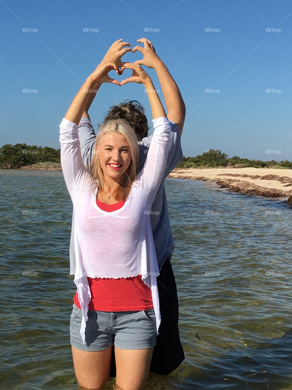 Young making heart shape in lake