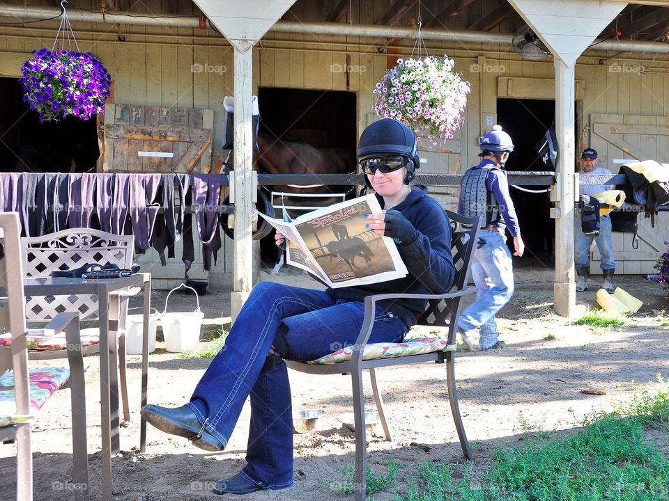 Opening Day at Saratoga.  Ready to start the Saratoga season with female exercise rider relaxing with the DRF on the backstretch. 
Fleetphoto