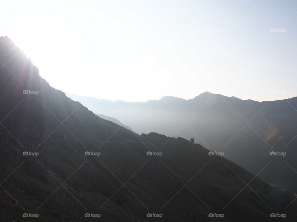 Sunrise over the mountains with dusty, bright light.