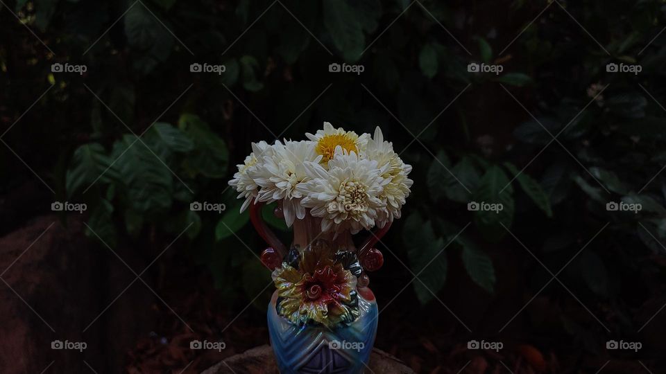 Beautiful white flowers in a colourful flowerpot with a flower sculpture, Flowers in a vase, colourful vase, white flowers in a vase