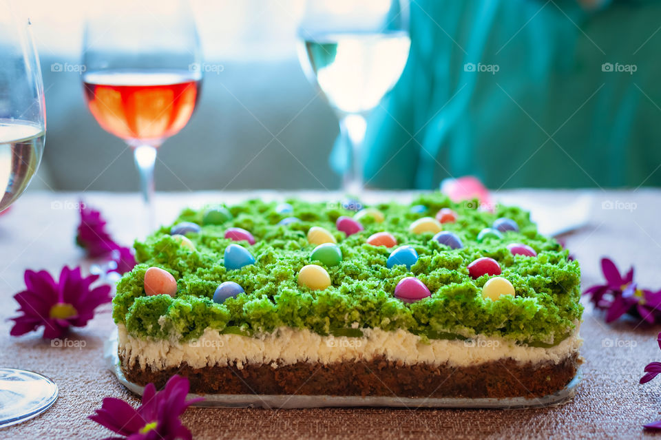 Delicious home baked cheesecake with grass like top decoration and colorful sweets.