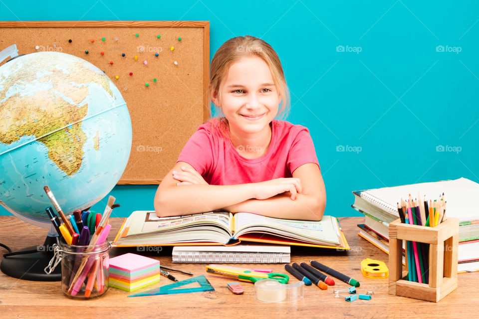 Girl doing her homework. Young smiling girl doing her homework