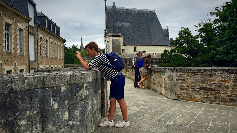 A tourist woman tales a photo at Nantes castle, France