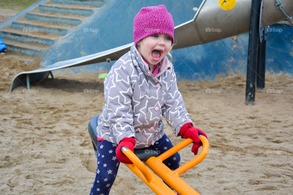 Cute girl sitting on seesaw