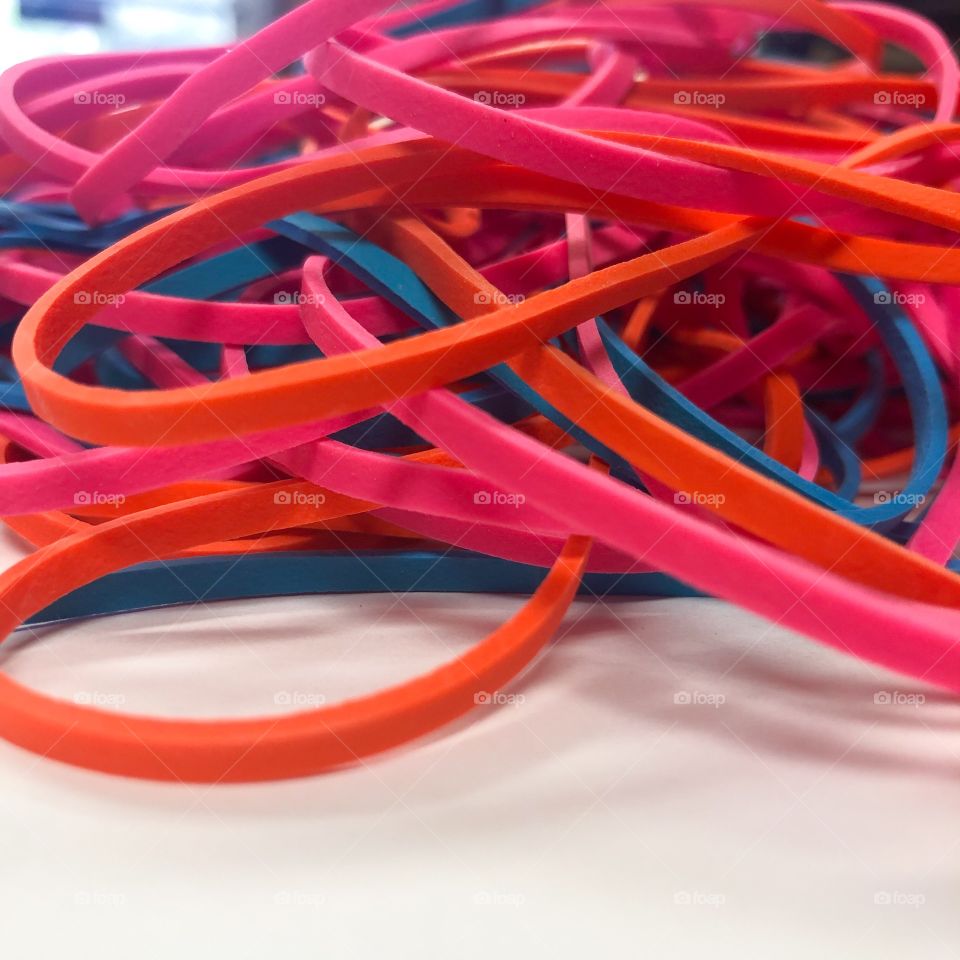 Red, pink, orange and blue colored rubber bands 